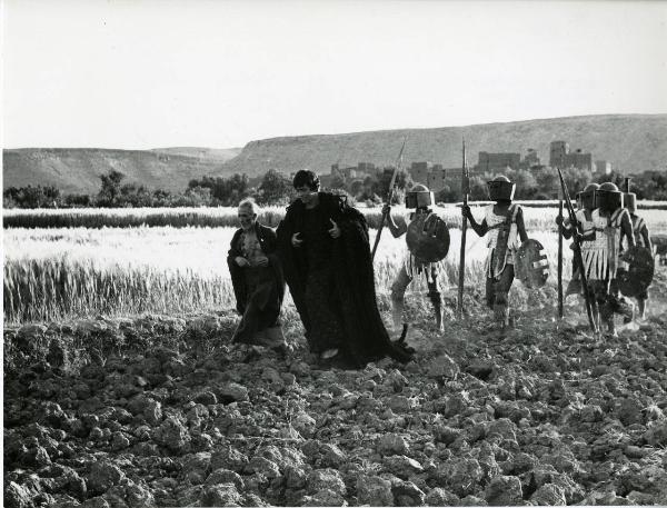 Scena del film "Edipo Re" - Regia Pier Paolo Pasolini, 1967 - Al centro, Franco Citti cammina in territorio desertico affiancato da un attore non identificato a torso nudo e seguito da attori non identificati che indossano delle armature.