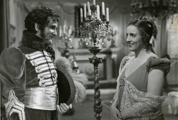 Scena del film "Le educande di Saint-Cyr" - Regia Gennaro Righelli, 1939 - A sinistra, Carlo Tamberlani e, a destra, Maria Jacobini si osservano sorridenti.