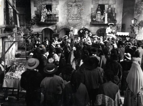 Scena del film "Elisir d'amore" - Regia Amleto Palermi, 1941- Totale di una piazza in cui è presente un gran numero di attori non identificati che ascoltano Armando Falconi, in piedi su un calesse.