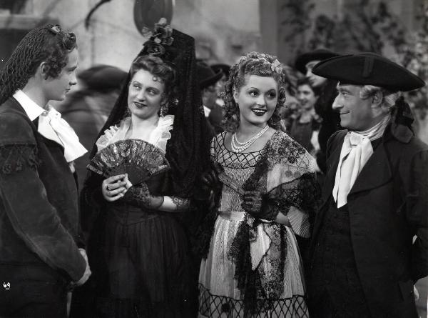 Scena del film "Elisir d'amore" - Regia Amleto Palermi, 1941- A sinistra, Roberto Villa e Margherita Carosio si osservano intensamente. A destra, Luigi Almirante guarda un'attrice non identificata sorridendo.