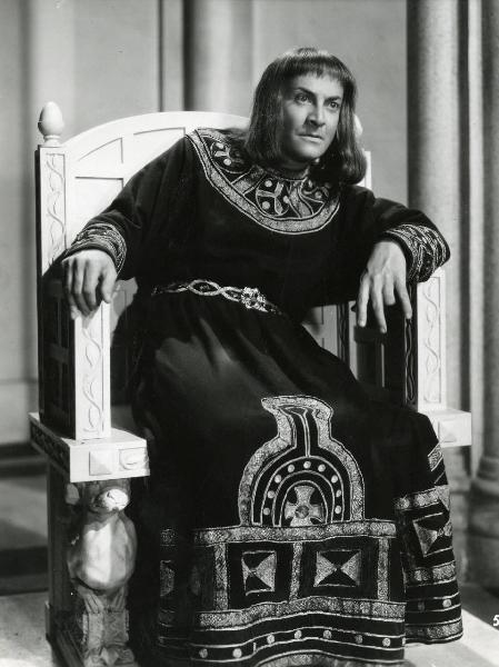 Scena del film "Enrico IV" - Regia Giorgio Pastina - 1943 - Osvaldo Valenti, in abiti di scena, siede su un trono e osserva dritto davanti a sé.
