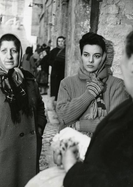 Scena del film "Era notte a Roma" - Regia Roberto Rossellini, 1960 - Mezza figura di Giovanna Ralli che, con il capo coperto e i guanti, rivolge lo sguardo a sinistra. Intorno a lei, attrici non identificate.