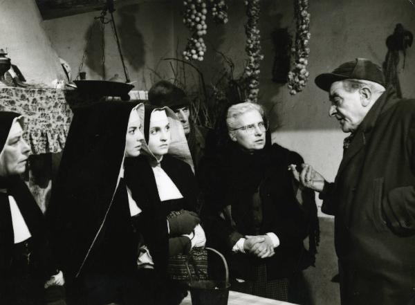 Scena del film "Era notte a Roma" - Regia Roberto Rossellini, 1960 - Attori non identificati ascoltano un attore non identificato, a destra, che sta parlando con una sigaretta in mano.