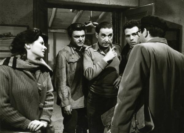 Scena del film "Era notte a Roma" - Regia Roberto Rossellini, 1960 - Leon Genn, al centro, e un attore non identificato di spalle discutono mentre Giovanna Ralli, a sinistra, Serghej Bondarciuk e Renato Salvatori, a destra, li ascoltano.