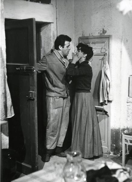 Scena del film "Era notte a Roma" - Regia Roberto Rossellini, 1960 - Figure intere di Serghej Bondarciuk, a sinistra, vicino a una porta aperta mentre discute con un'attrice non identificata di fronte a lui.