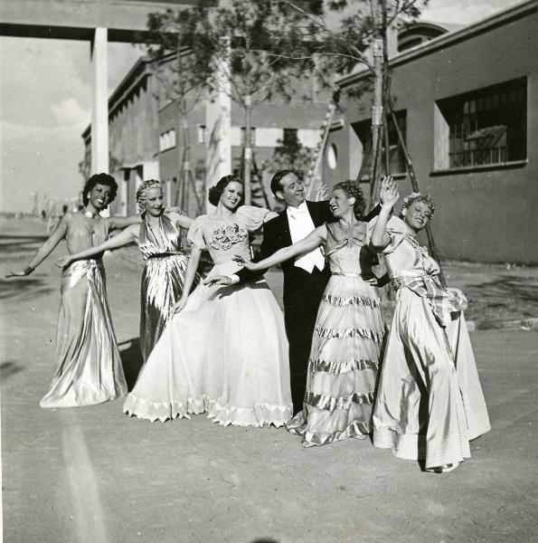 Sul set del film "Eravamo 7 sorelle" - Regia Nunzio Malasomma, 1939 - In posa da sinistra: un'attrice non identificata, Olivia Fried, Elena Altieri, Nino Besozzi, Lotte Menas e un'altra attrice non identificata.