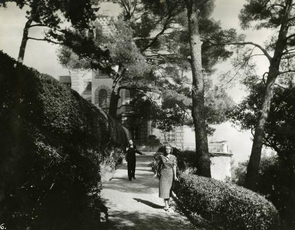 Scena del film "Eravamo 7 sorelle" - Regia Nunzio Malasomma, 1939 - Figura intera di Paola Barbara che cammina verso l'obiettivo. Alle sue spalle, Nino Besozzi allunga il braccio verso di lei.