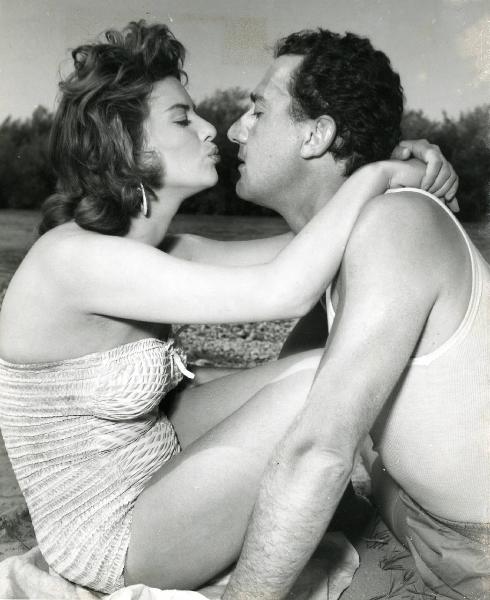 Scena del film "Un eroe dei nostri tempi" - Regia Mario Monicelli, 1955 - Su una spiaggia: Giovanna Ralli stringe le braccia intorno al collo di Alberto Sordi, intenta a baciarlo. Intanto lui la guarda.