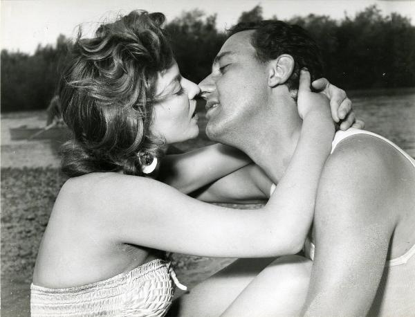 Scena del film "Un eroe dei nostri tempi" - Regia Mario Monicelli, 1955 - Su una spiaggia: Giovanna Ralli stringe le braccia intorno al collo di Alberto Sordi mentre si scambiano un bacio.