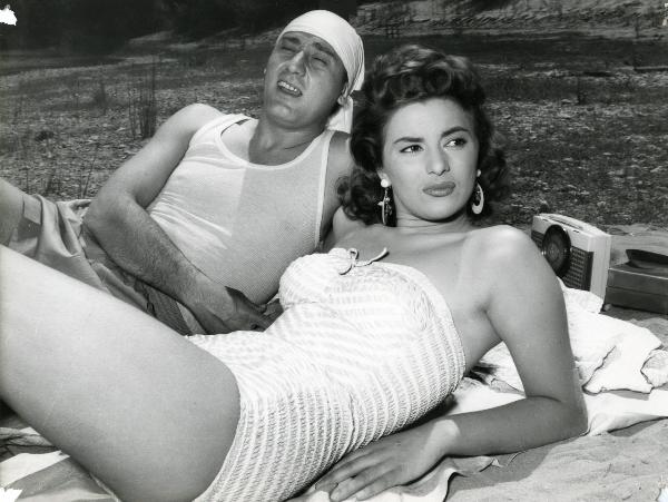 Scena del film "Un eroe dei nostri tempi" - Regia Mario Monicelli, 1955 - Sdraiati su una spiaggia: Giovanna Ralli rivolge lo sguardo verso destra mentre Alberto Sordi, in secondo piano, rivolge lo sguardo a sinistra.