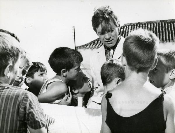 Scena del film "Eroe vagabondo" - Regia Walter Santesso, 1966 - Walter Santesso, al centro, è attorniato da piccoli attori non identificati che lo ascoltano.