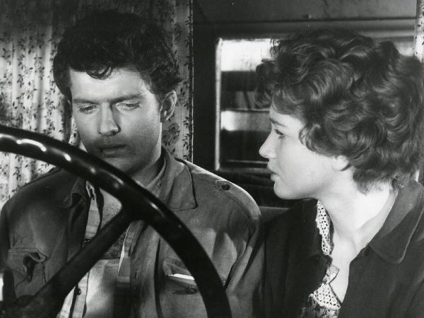 Scena del film "Esterina" - Regia Carlo Lizzani, 1959 - In un autoveicolo, Geoffrey Horne, a sinistra, volge lo sguardo verso il basso. A destra, Carla Gravina lo osserva.