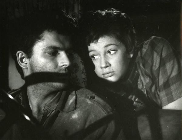 Scena del film "Esterina" - Regia Carlo Lizzani, 1959 - In un autoveicolo, Carla Gravina, a destra, osserva Geoffrey Horne, a sinistra, che guarda da sopra la propria spalla.