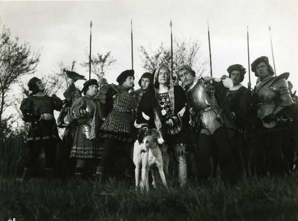 Scena del film "Ettore fieramosca" - Regia Alessandro Blasetti, 1938 - In primo piano, da destra: Carlo Duse, Osvaldo Valenti che appoggia la mano sinistra su due cani e Virgilio Gottardi. Dietro, un gruppo di soldati non identificati.