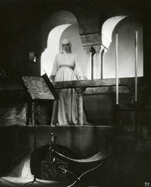 Scena del film "Ettore fieramosca" - Regia Alessandro Blasetti, 1938 - Elisa Cegani, su un balcone, appoggia le mani sulla ringhiera in pietra e guarda dritto davanti a sé.