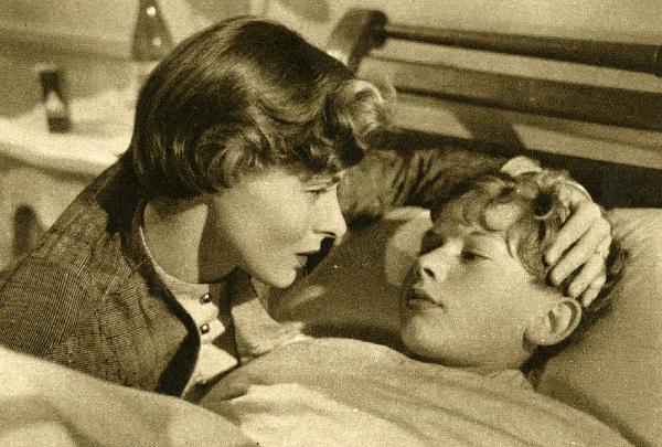 Scena del film "Europa 51" - Regia Roberto Rossellini, 1952 - Ingrid Bergman, a sinistra, appoggia la mano sinistra sul capo di Sandro Franchina, steso su un letto.