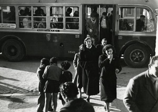 Scena del film "Europa 51" - Regia Roberto Rossellini, 1952 - Ingrid Bergman, al centro in piedi, si dirige e osserva dritto davanti a sé. Intorno, sono presenti attori e attrici non identificati.