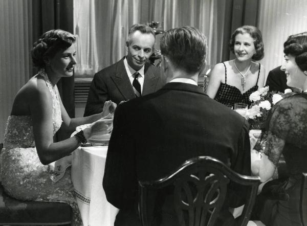 Scena del film "Europa 51" - Regia Roberto Rossellini, 1952 - Ingrid Bergman, a sinistra, guarda i due attori non identificati di spalle in primo piano. Al centro, Ettore Giannini la osserva sorridente, insieme a un'attrice non identificata.