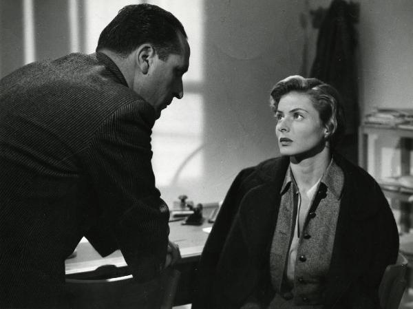 Scena del film "Europa 51" - Regia Roberto Rossellini, 1952 - Mezza figura di Ingrid Bergman, seduta a destra, che osserva ricambiata, un attore non identificato, sulla sinistra di spalle.