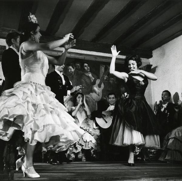 Scena del film "Europa di notte" - Regia Alessandro Blasetti, 1959 - Due attrici non identificate ballano, e una terza le osserva applaudendo seguita da altri attori non identificati. Al centro, un attore non identificato suona una chitarra.