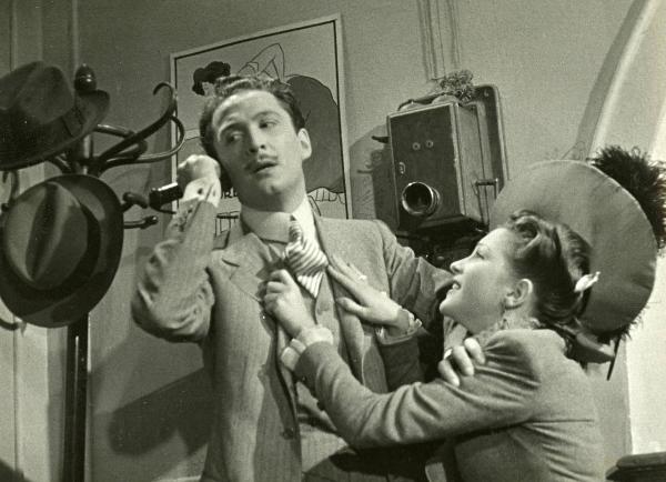 Scena del film "La fabbrica dell'imprevisto" - Regia Jacopo Comin, 1942 - Mentre parla al telefono guardando verso sinistra, Maurizio D'Ancora tenta di allontanare con una mano Vera Bergman che lo afferra per la giacca.