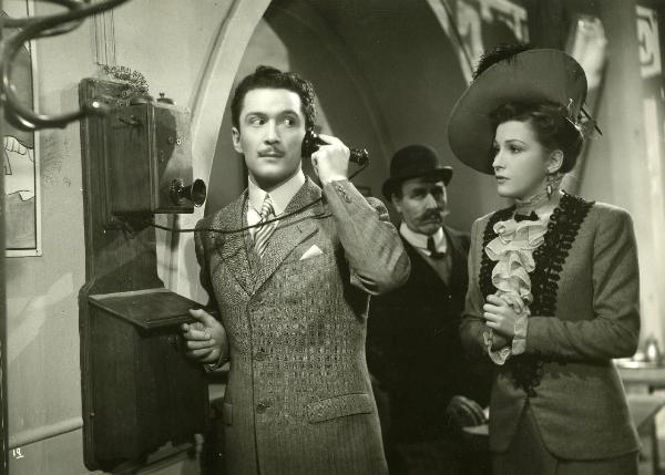 Scena del film "La fabbrica dell'imprevisto" - Regia Jacopo Comin, 1942 - Maurizio D'Ancora mentre è al telefono si rivolge alla sua destra. Nel mentre, Vera Bergman con le mani giunte lo osserva.