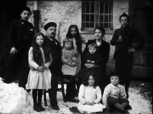 Piazza Brembana. Ritratto di Girolamo Calvi con la moglie e i figli (tra cui compaiono i quattro ''fratelli Calvi", eroi della Prima Guerra Mondiale) sul retro della sua casa. Terreno innevato