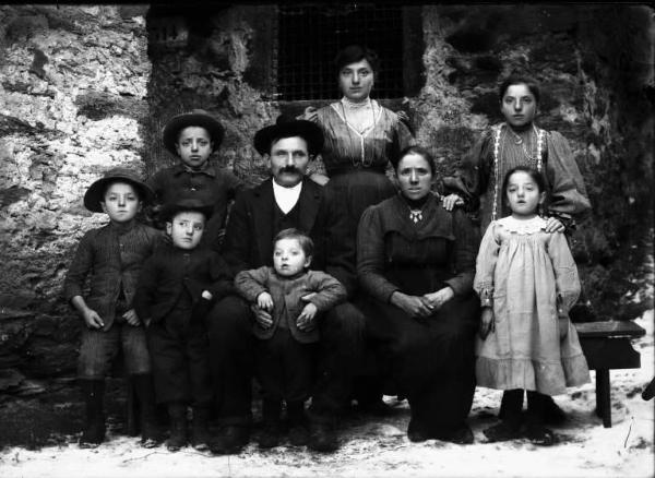 Val Brembana. Ritratto di famiglia con casa rurale sullo sfondo. Terreno innevato