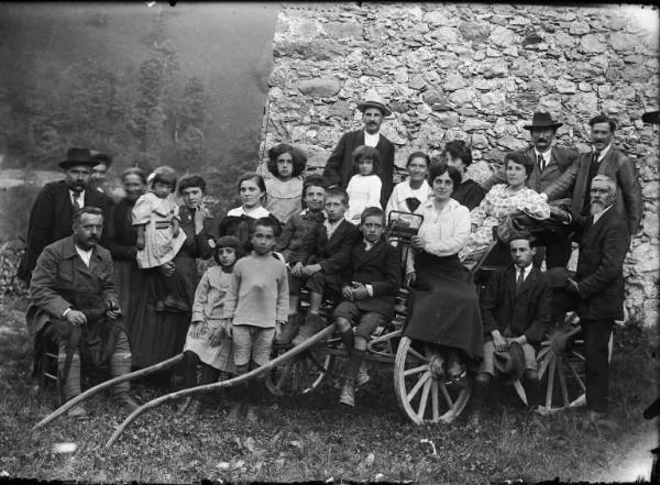 Val Brembana. Ritratto di gruppo sopra e attorno a una carrozza in prossimità di una casa rurale