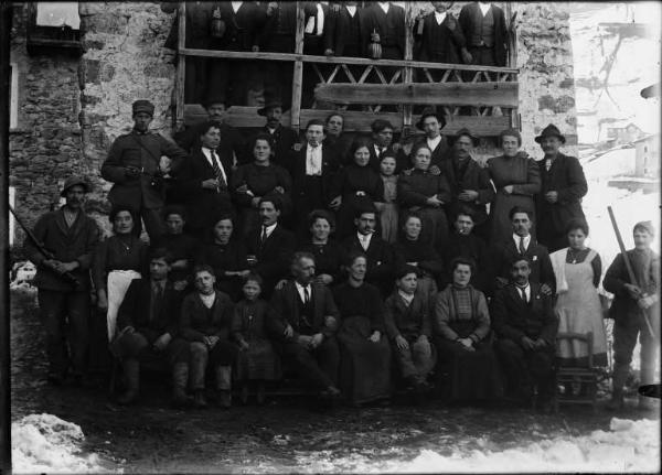 Val Brembana. Ritratto di gruppo in occasione di un matrimonio in prossimità di una casa rurale. Paesaggio montano innevato sullo sfondo