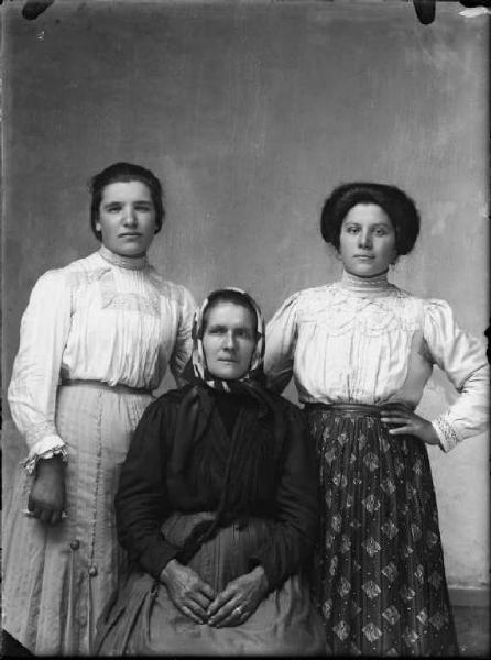 Val Brembana. Ritratto di donna con fazzoletto in testa e due ragazze