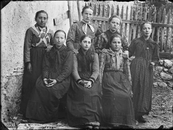 Val Brembana. Ritratto di gruppo di donne all'esterno di una casa rurale con staccionata sullo sfondo