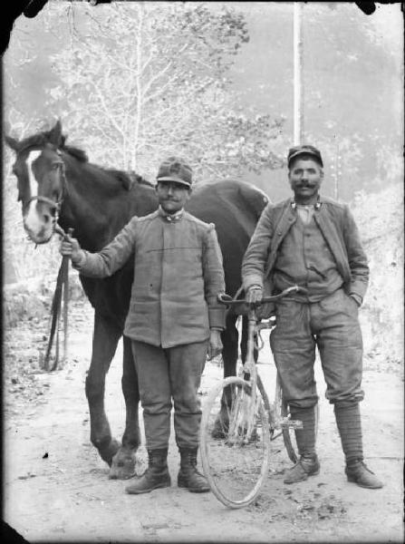 Val Brembana. Ritratto di due militari con cavallo e bicicletta in una strada di montagna