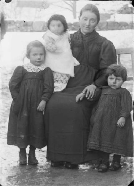 Val Brembana. Ritrattto di donna con tre bambini in un paesaggio innevato