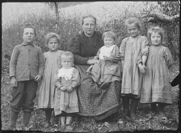 Val Brembana. Ritratto di donna con bambini in un campo