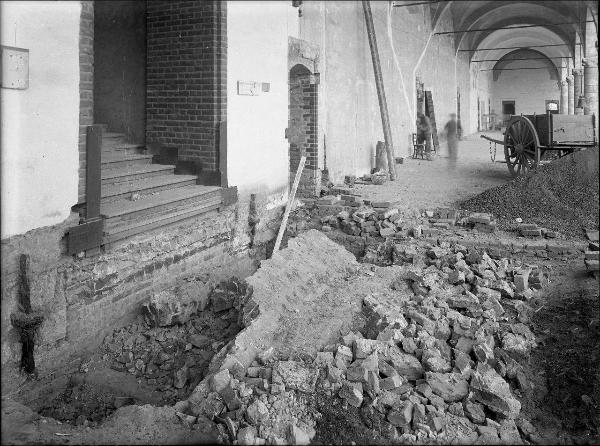 Pavia - Castello visconteo - Porticato meridionale - Lavori nel tratto di porticato in corrispondenza della scalinata - Operai al lavoro - Carro di legno e campanella