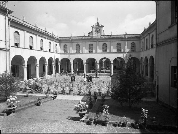 Pavia - Viale Matteotti 63 - Casa di riposo «F. Pertusati» - Scorcio panoramico del cortile d'ingresso - Gruppi di donne e uomini anziani con suore nel giardino fiorito