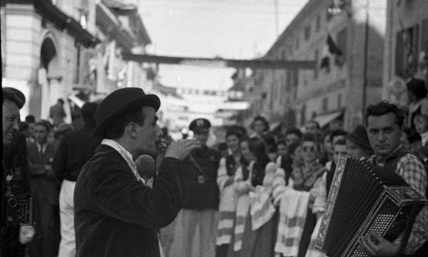 Garlasco - Piazza della Repubblica (già Vittorio Emanuele II) - Festa delle mondine - Suonatori (un fisarmonicista) in primo piano - Gruppo di giovani donne con abiti tradizionali - Guglielmo Chiolini fotografo