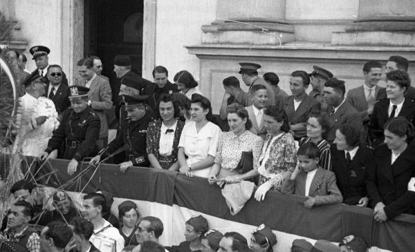 Garlasco - Piazza della Repubblica (già Vittorio Emanuele II) - Festa delle mondine - Palco delle autorità con esponenti del Partito Fascista - Bandiera italiana disposta lungo il palco - Folla - Chiesa della Beata Assunta, scorcio