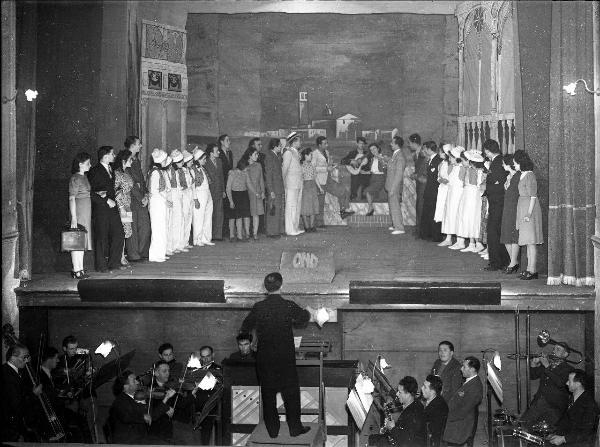 Garlasco - Via Santissima Trinità 6 - Teatro Martinetti - Interno - Palcoscenico gruppo persone - Quinte sceniche e fondale - Buca d'orchestra e maestro in posizione centrale e sopraelevata - Scritta O.N.D. sulla copertura della buca del suggeritore