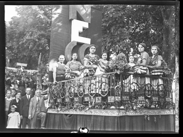 Ritratto di gruppo - Uomini e donne in abiti tradizionali posano sul carro realizzato dall'azienda Necchi - Pavia - 3° Festa nazionale dell'uva