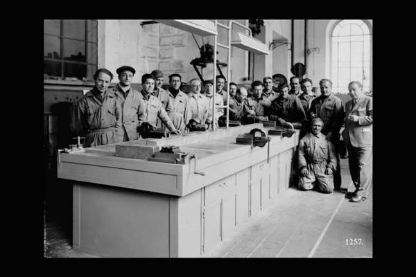 Società Edison - Cedegolo - Centrale idroelettrica - Operai, tecnici e un dirigente in posa intorno a un banco di lavoro