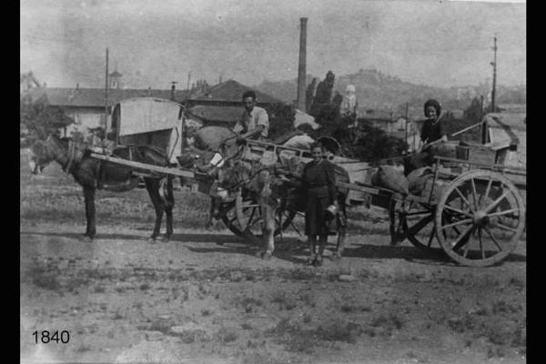 Due carretti trainati da muli con masserizie e tre persone in posa.