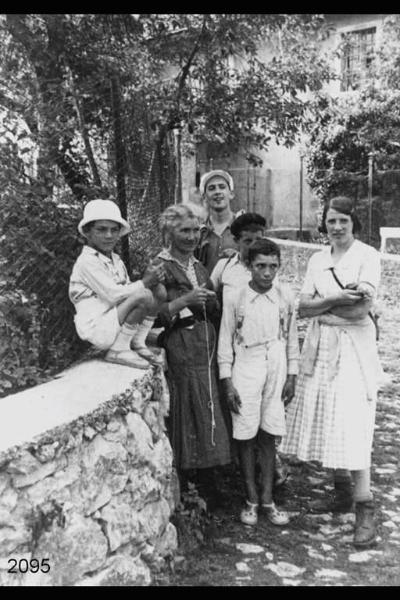 Al centro Antonia Acerno. Bambini e due donne lungo una strada di campagna.