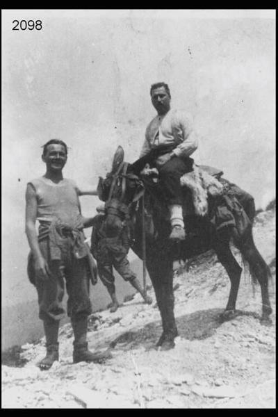 Ottavio Rota sul mulo accanto alla croce del Resegone. Due uomini.