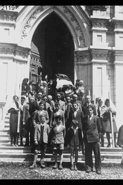 Funerale di Andrea Capelli. Gruppo all'esterno della chiesa. Il feretro portato a spalle.