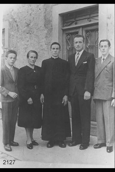 Don Mario Pellegrini, missionario in Tailandia, con i genitori. Posa in piedi, all'esterno di abitazione.