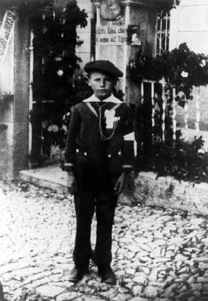 Giovanni Maconi vestito da marinaretto con fascia al braccio e medaglia al petto.