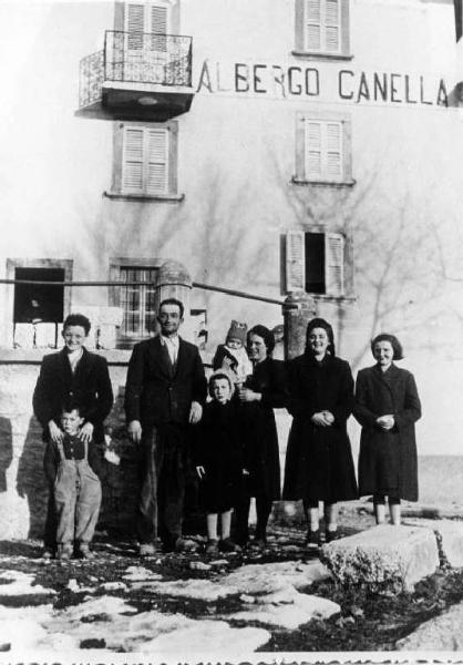 Giovanni Canella, la moglie Sandra Bolis, i figli. Sul fondo, un edificio con scritta: "ALBERGO CANELLA".