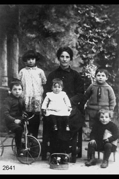 Maria Rodeschini con cinque figli. Un bambino sul triciclo e uno con un libro.